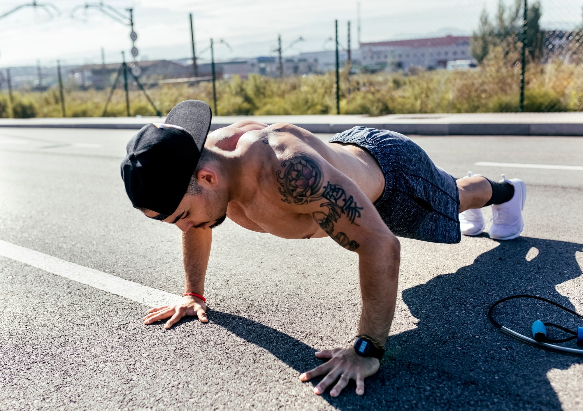 Young man doing push ups on a road